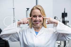 Female optometrist pointing at her eyes