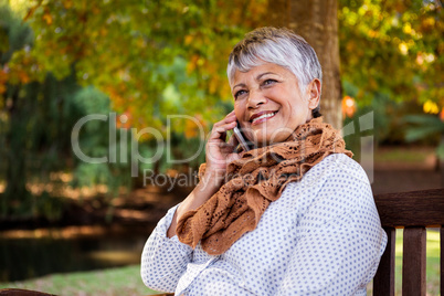 Mature woman talking on cellphone at park