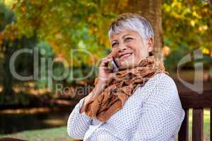 Mature woman talking on cellphone at park