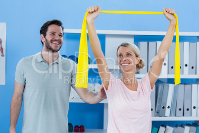 Physiotherapist correcting position of female patient