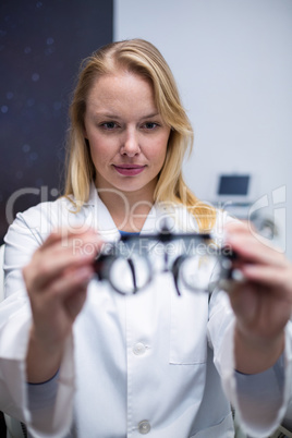 Beautiful female optometrist holding messbrille