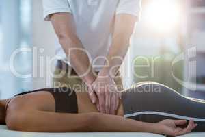 Male physiotherapist giving back massage to female patient