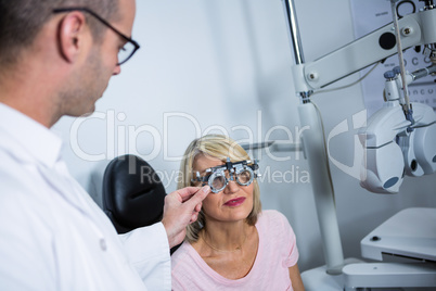 Optometrist examining female patient with messbrille