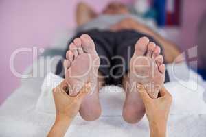 Senior man receiving foot massage from physiotherapist