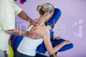 Physiotherapist giving back massage to a patient