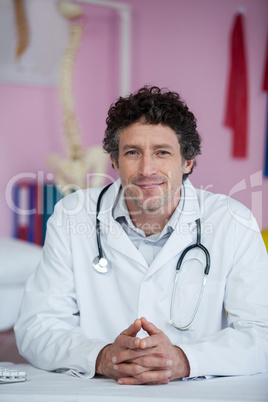 Portrait of physiotherapist sitting in clinic