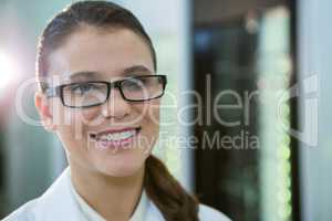 Optometrist in spectacles smiling in optical store