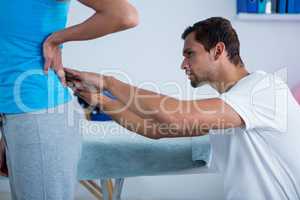 Physiotherapist examining womans back