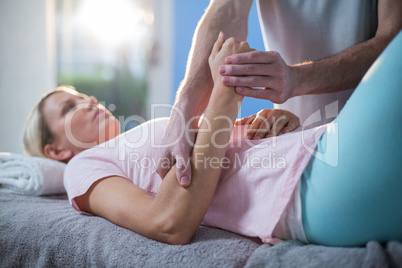 Physiotherapist massaging hand of a female patient