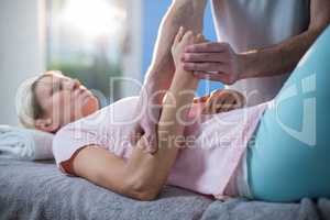 Physiotherapist massaging hand of a female patient