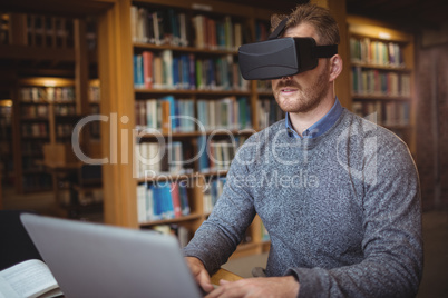 Mature student in virtual reality headset using laptop