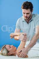 Woman receiving shoulder therapy from physiotherapist