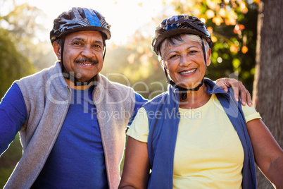 Portrait of mature couple holding cycling helmet