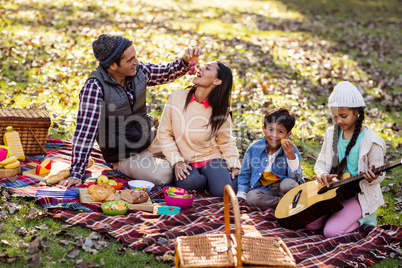 Man feeding fruit to woman