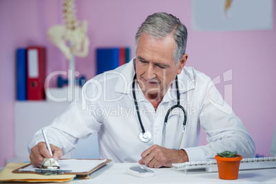 Physiotherapist writing on clipboard