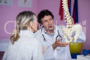 Physiotherapist explaining the spine model to patient