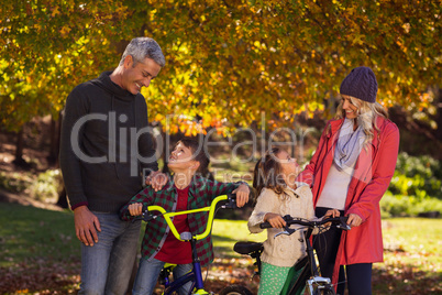 Happy children riding bicycles with parents