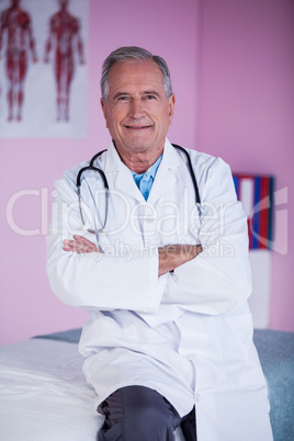 Portrait of physiotherapist sitting with arms crossed