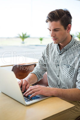 Man using laptop in coffee shop