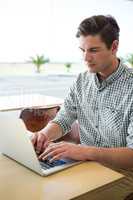 Man using laptop in coffee shop