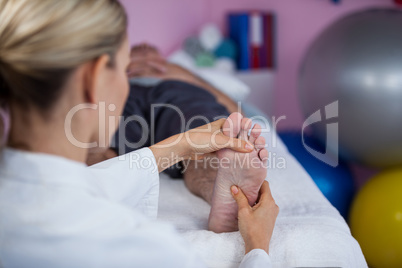 Physiotherapist giving foot massage to a patient