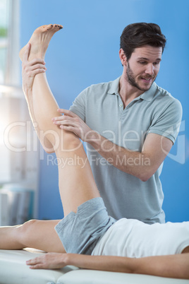 Male physiotherapist giving knee massage to female patient