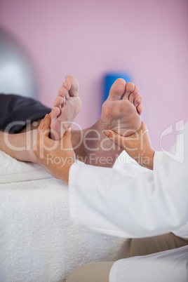 Senior man receiving foot massage from physiotherapist