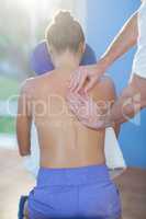 Physiotherapist giving back massage to a female patient