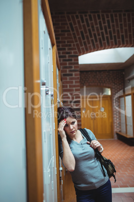 Stressed mature student standing in locker room