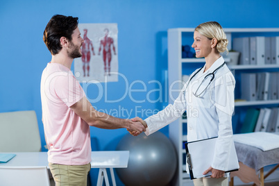 Physiotherapist shaking hands with male patient