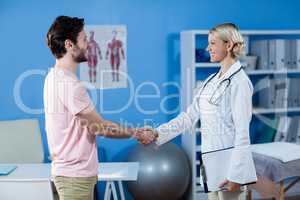 Physiotherapist shaking hands with male patient