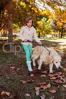 Little girl taking for a walk her dog
