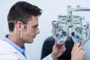 Attentive optometrist adjusting phoropter