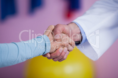 Physiotherapist shaking hands with patient