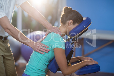 Physiotherapist giving back massage to a female patient