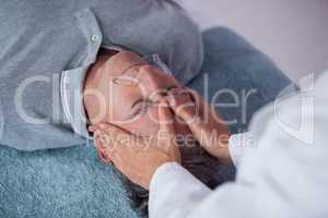 Senior man receiving head massage from physiotherapist