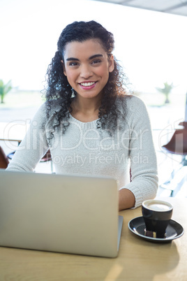 Woman using laptop and a coffee cup on the table in the coffee s