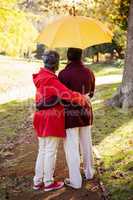 Couple holding umbrella while embracing