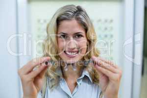 Smiling female customer trying spectacles