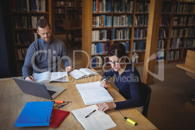 Mature students working together in college library