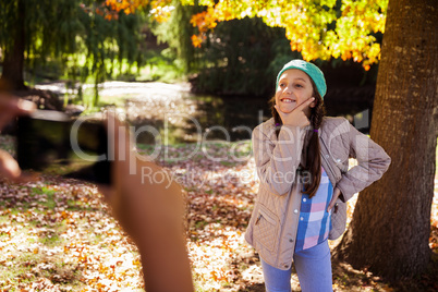 Cropped image of boy photographing girl in park