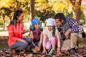Happy family playing with autumn leaves