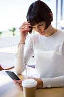 Tense woman using mobile phone