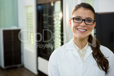 Optometrist in spectacles smiling in optical store