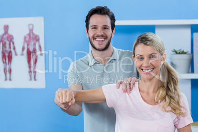 Physiotherapist stretching arm of a female patient