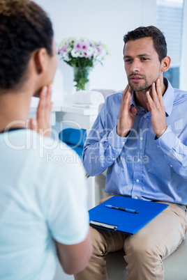 Physiotherapist talking with patient with neck pain