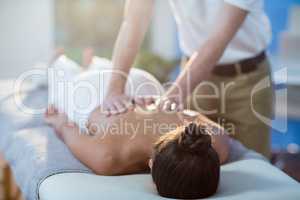 Male physiotherapist giving back massage to female patient