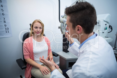 Optometrist assisting female patient