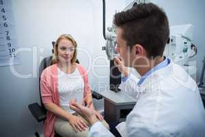 Optometrist assisting female patient