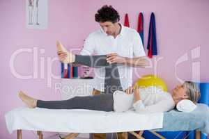 Physiotherapist giving leg massage to a senior woman